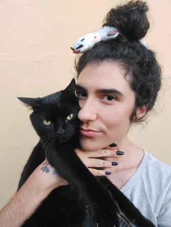 xRainbow Rafa Beleze holding a black cat.